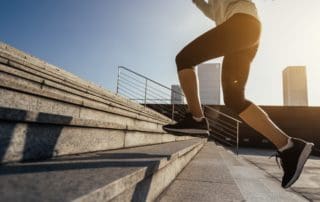 Fitness sports woman running up stairs in city
